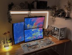 three computer monitors sitting on top of a wooden desk next to a clock and other items