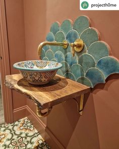 a bathroom sink sitting on top of a wooden counter next to a wall mounted faucet