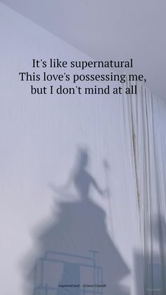 the shadow of a person on a wall next to a sign that says it's like supernatural this love's possessing me, but i don't mind at all