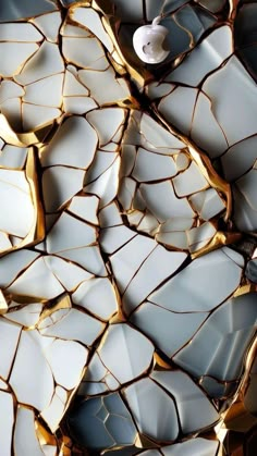 an apple logo sitting on top of a cracked glass wall with gold and white tiles