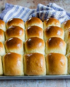 a pan filled with rolls sitting on top of a wooden table