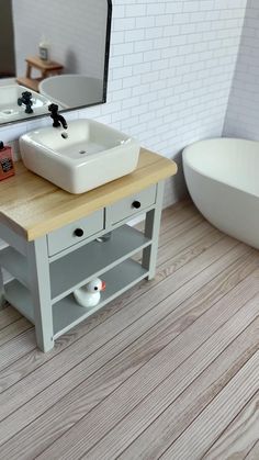 a bathroom with a sink, mirror and bathtub on the floor in front of it