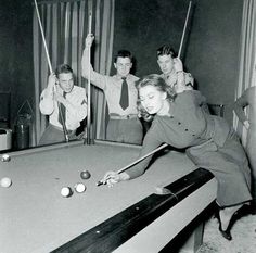 an old black and white photo of people playing pool