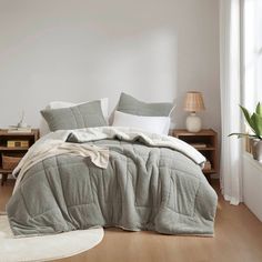 a bed in a bedroom with white walls and wooden flooring next to a window