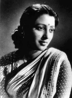 an old black and white photo of a woman wearing a sari with dots on it