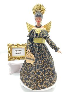 an angel figurine next to a plaque with the name queen angel on it