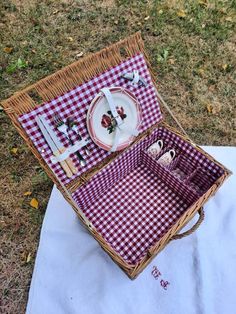 a picnic set up in a wicker basket with plates and utensils on it