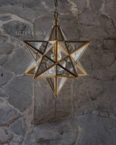 a star hanging from a chain on a stone wall