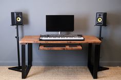 a computer desk with speakers and a keyboard