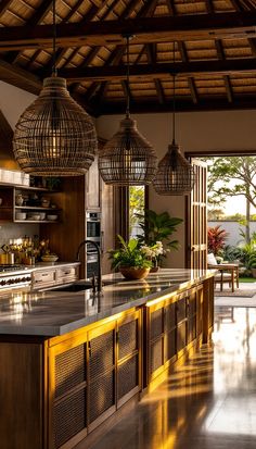 a large kitchen with wooden cabinets and hanging lights over the counter top, along with potted plants