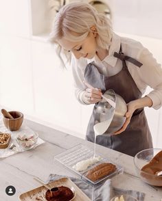 a woman in an apron pouring chocolate into a bowl