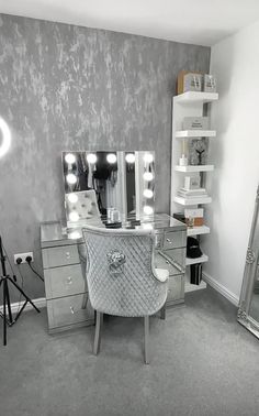 a room with a vanity, mirror and lights on the wall next to a chair