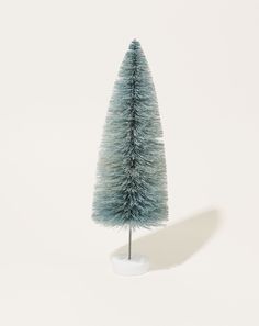 a small blue christmas tree sitting on top of a white table