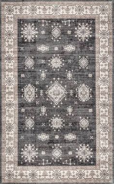 a gray and white rug with snowflakes on the bottom, in front of a black background