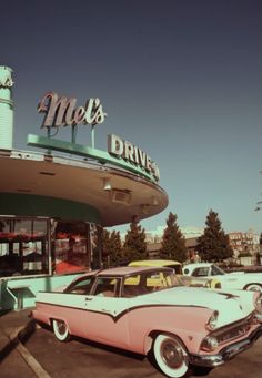 an old pink car parked in front of a drive - in movie theater with the name mel's drive - in written on it