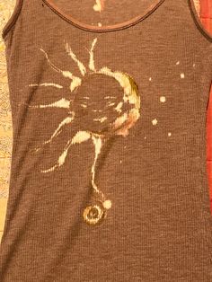 a brown tank top with an image of a sun on it