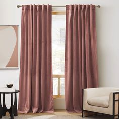 a living room with pink curtains and a chair