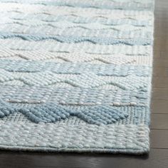 a blue and white rug on top of a wooden floor