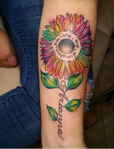 a colorful sunflower tattoo on the arm with an inspirational quote written in cursive writing