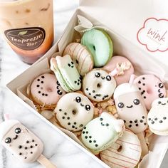 a box filled with donuts next to a cup of coffee and an iced drink