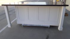 a white bar with black counter top sitting in front of a building