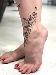 a woman's foot with a flower tattoo on the top and bottom part of her leg