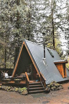 a small cabin in the woods with stairs leading up to it's roof and windows