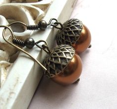 Here is an adorable pair of copper colored, acorn earrings, featuring glass pearl beads along with detailed brass acorn bead caps. These earrings come on nice quality brass ear wires, which are lead and nickel safe. These sweet nature inspired earrings are a great addition to any fall wardrobe and perfect for a woodland style wedding! Matching necklace available  here: https://www.etsy.com/listing/183919102/copper-acorn-necklace-pearl-acorn Total length of earrings  is 1.25 inches long from the Acorn Caps, Acorn Jewelry, Acorn Earrings, Woodland Earrings, Alpha Gam, Woodland Jewelry, Acorn Necklace, Copper Diy, Fall Earrings