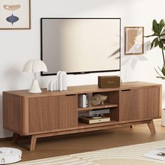 an entertainment center with a flat screen tv mounted on it's sideboard in a living room