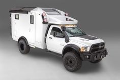 a white truck with an off - road camper on the back