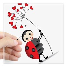 a ladybug with hearts attached to it's back is being held by a hand