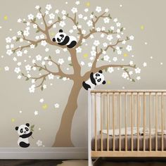 a baby's room with a tree and pandas on it