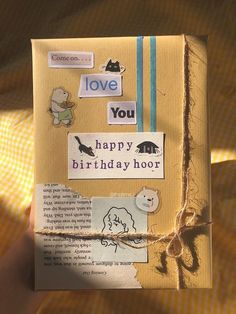 someone is holding up a birthday card made from an old book with stickers on it