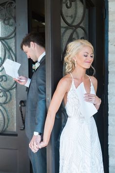 the bride and groom are holding hands as they stand in front of an open door