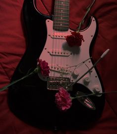 an electric guitar with flowers on the neck