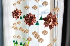 an origami christmas decoration hanging from a window