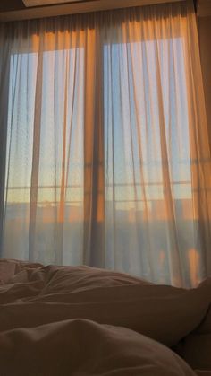 the sun is shining through the sheer curtains