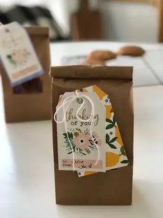 two brown bags with tags on them sitting on a table