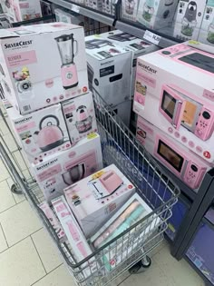 a shopping cart in a store filled with boxes and appliances, including pink microwaves