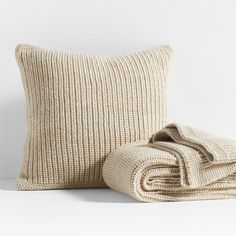 two pillows and a blanket on a white surface