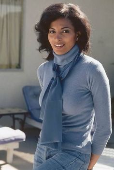 a woman wearing a blue sweater and tie