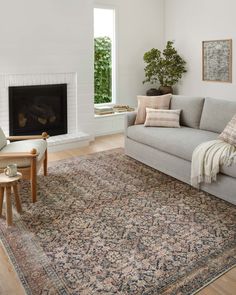 a living room filled with furniture and a large rug on top of a hard wood floor