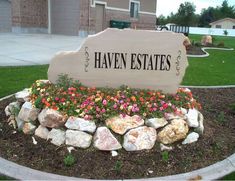 there is a sign that says haven estates in front of a building with flowers growing out of it