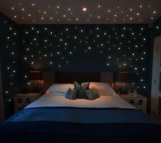 a bed in a room with stars on the wall above it and two night stands