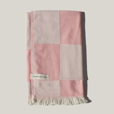 pink and white checkered blanket with fringes