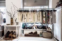 a room filled with lots of clothes and shoes next to a shelf full of purses