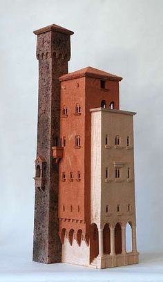 a tall brick building with two towers on each side and windows at the top, in front of a white background