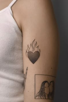 a woman's arm with a tattoo on it that has flames coming out of the heart