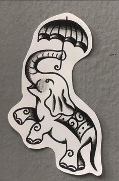 a sticker with an elephant holding a parasol in it's trunk, on top of a gray surface