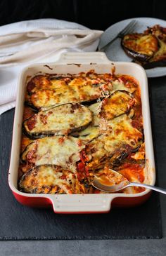 a casserole dish with zucchini and cheese in it on a table